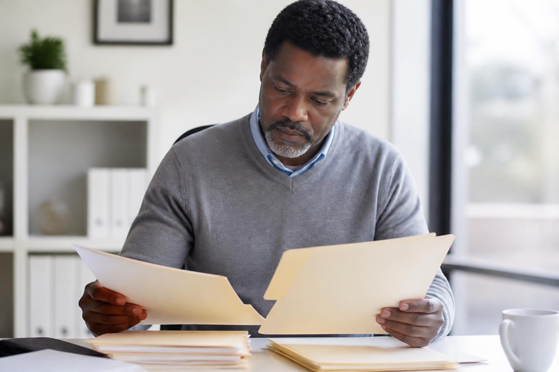 Professional reviewing document folders at a desk